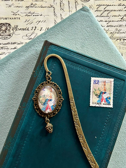 Segnalibro con ciondolo ovale in bronzo e francobollo giapponese di Peter Rabbit elegante all'appuntamento, di Beatrix Potter