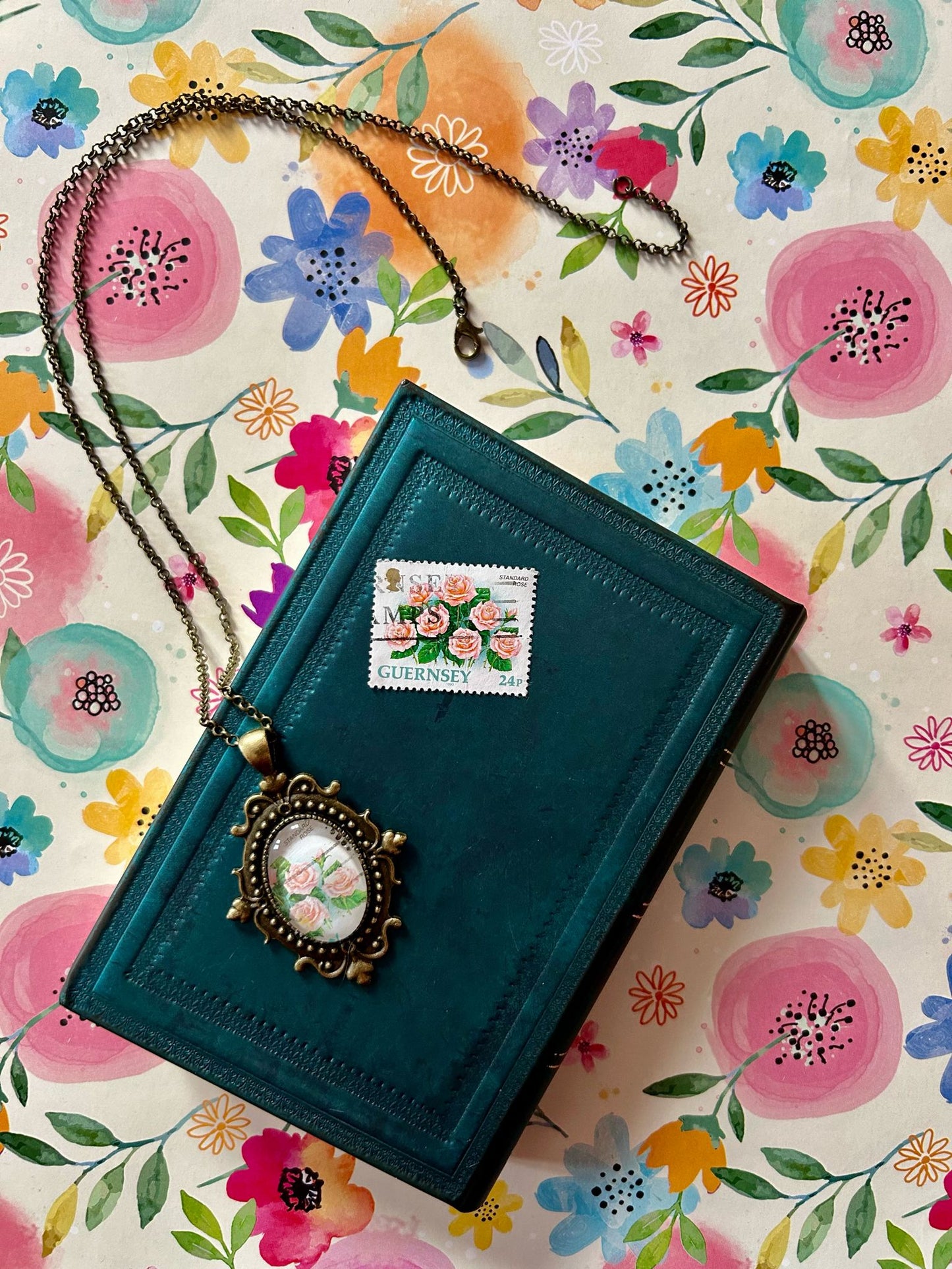 Collana ovale con bordi lavorati e francobollo d'epoca Guernsey con rose rosa