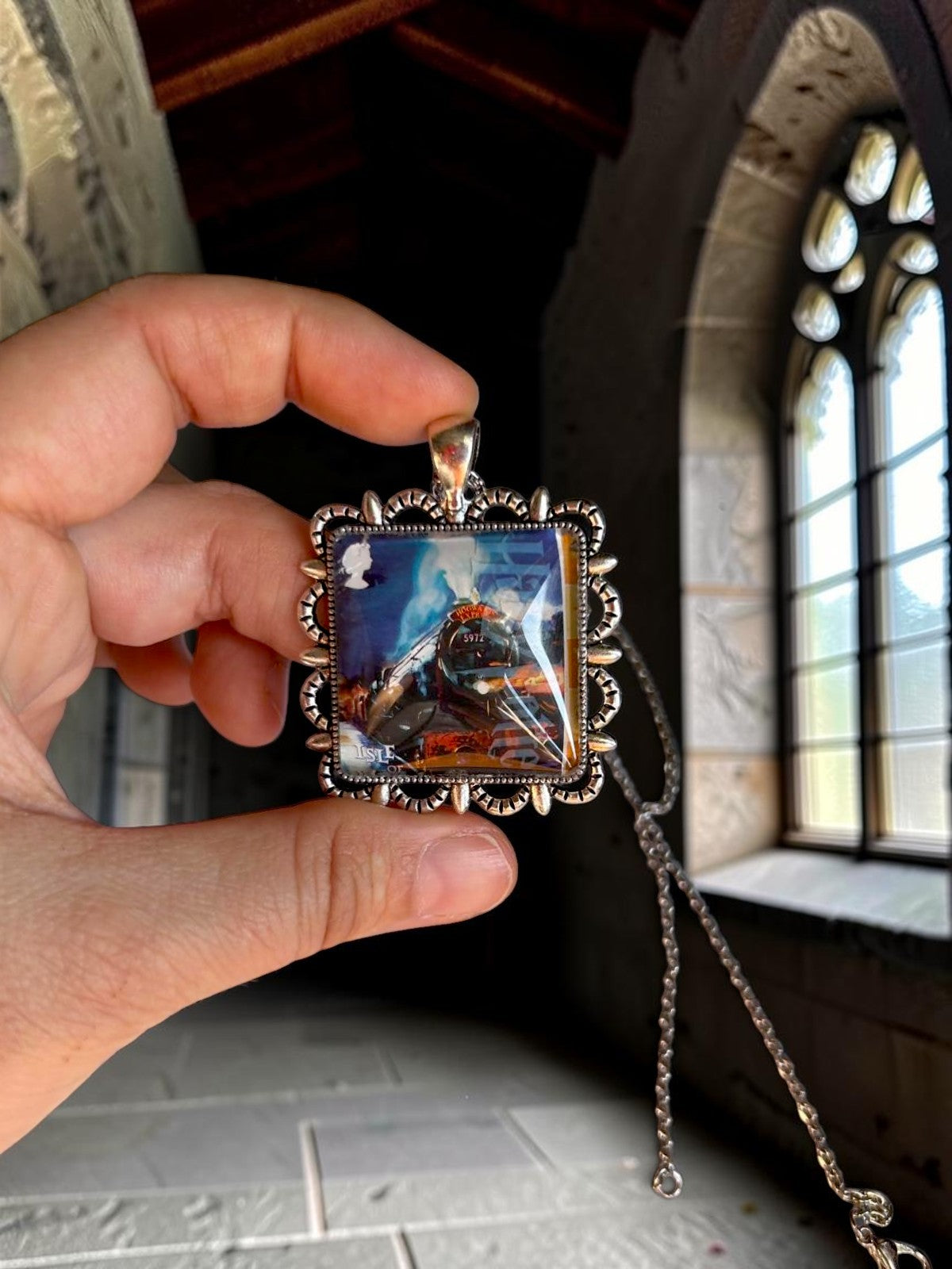 Collana artigianale italiana con l'Hogwarts Express in mano, ciondolo quadrato da francobollo dell'Isola di Man