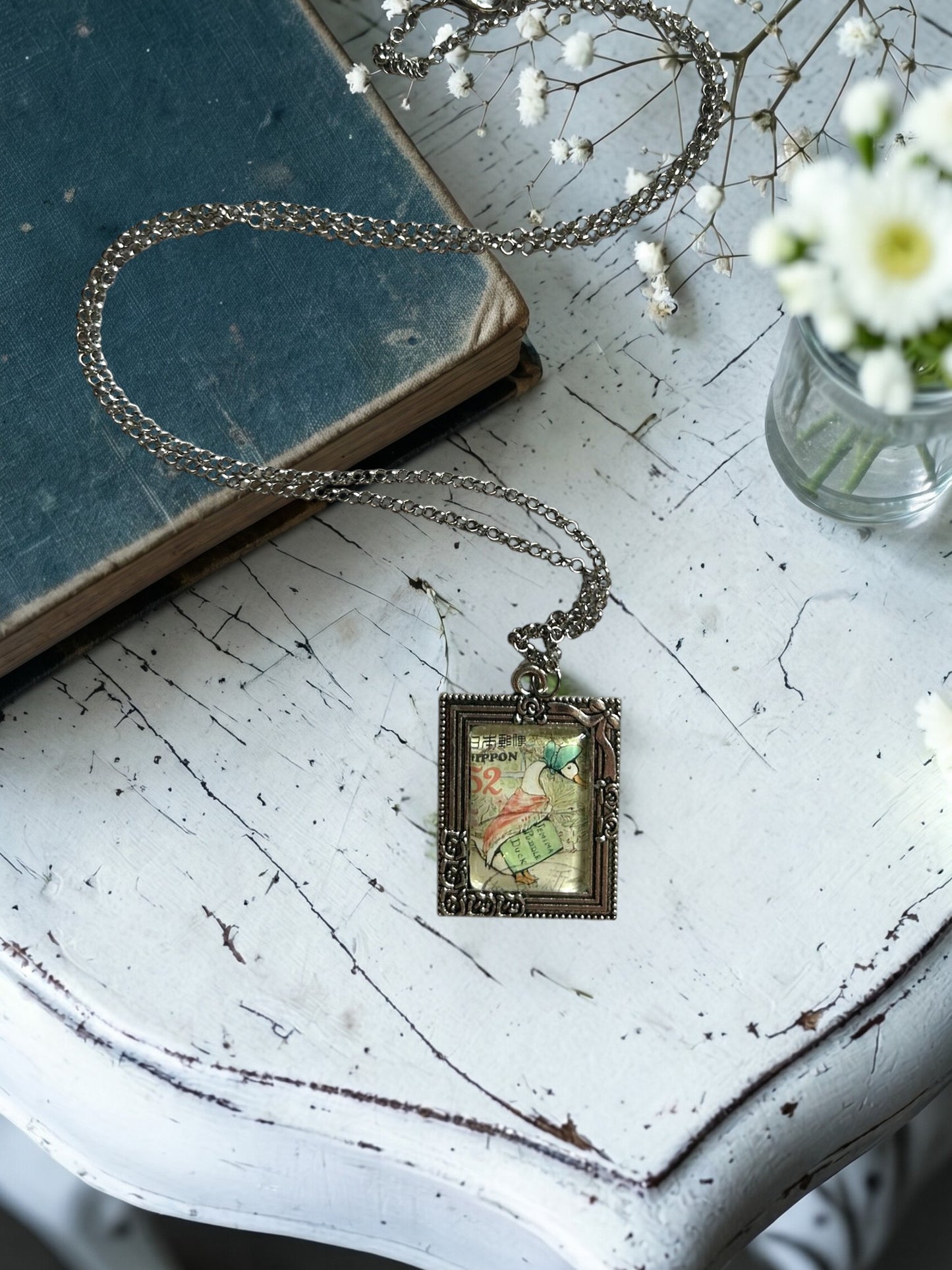 Collana con francobollo giapponese di Jemima, l'anatra di Beatrix Potter con cuffietta e scialle, cornice rettangolare in argento con rose, artigianato, Italia