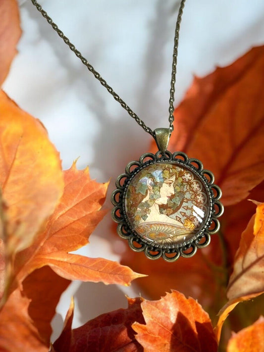 Collana artigianale con profilo femminile Art Nouveau di Mucha in montatura di bronzo, tra foglie d'autunno, gioielleria italiana
