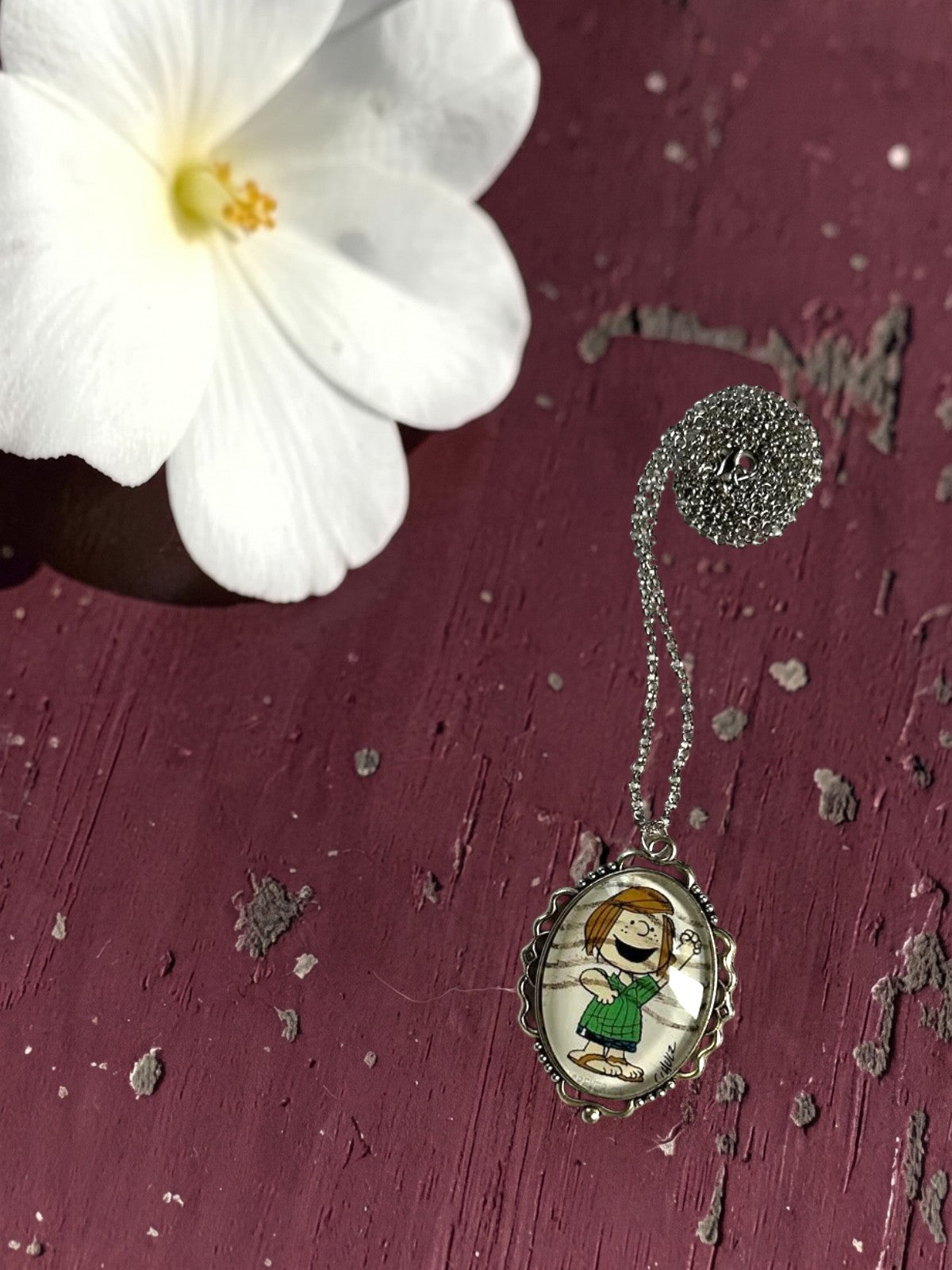 Collana artigianale con francobollo americano di Piperita Patty e fiore bianco su legno bordeaux, Italia