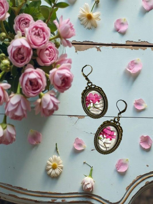 Orecchini artigianali con magnolia rosa da francobollo, montatura ovale color bronzo, realizzati in Italia