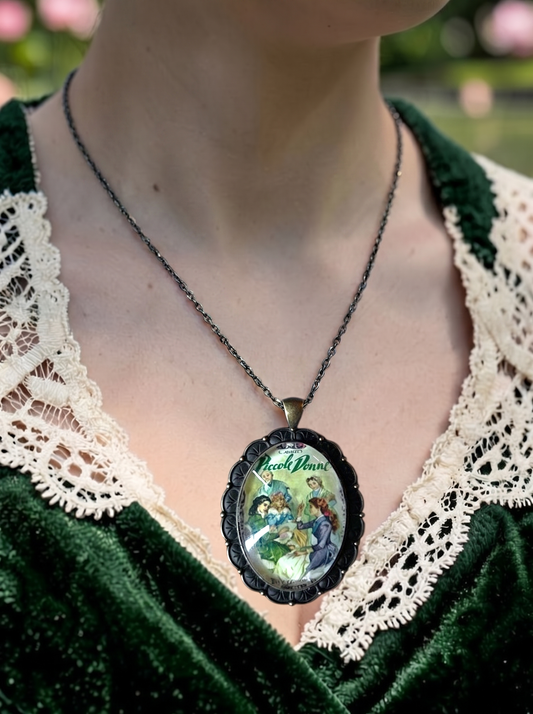 Collana artigianale italiana indossata su abito verde, ciondolo ovale con la copertina di Piccole Donne di Alcott