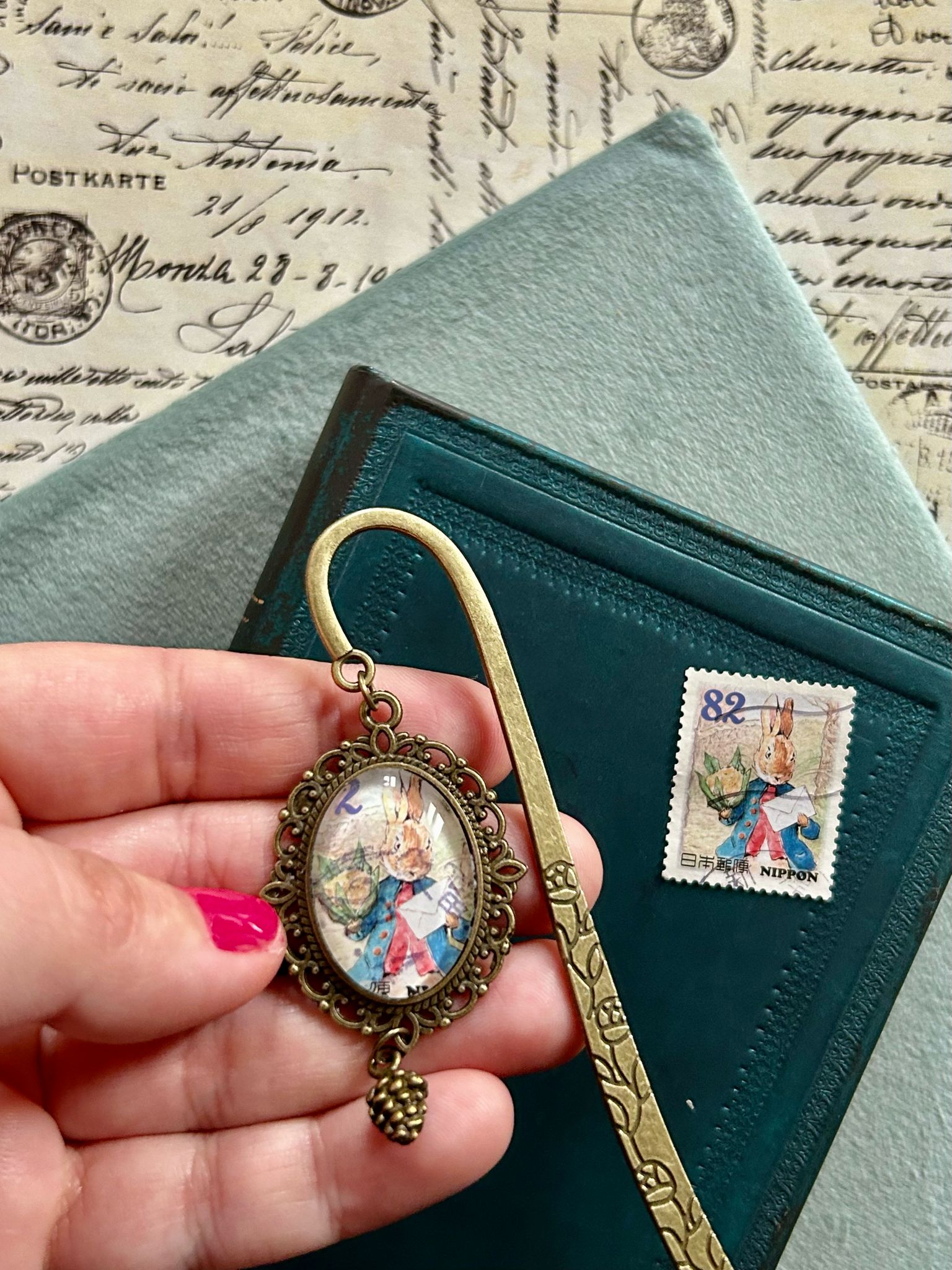 Segnalibro con ciondolo ovale in bronzo e francobollo giapponese di Peter Rabbit elegante all'appuntamento, di Beatrix Potter