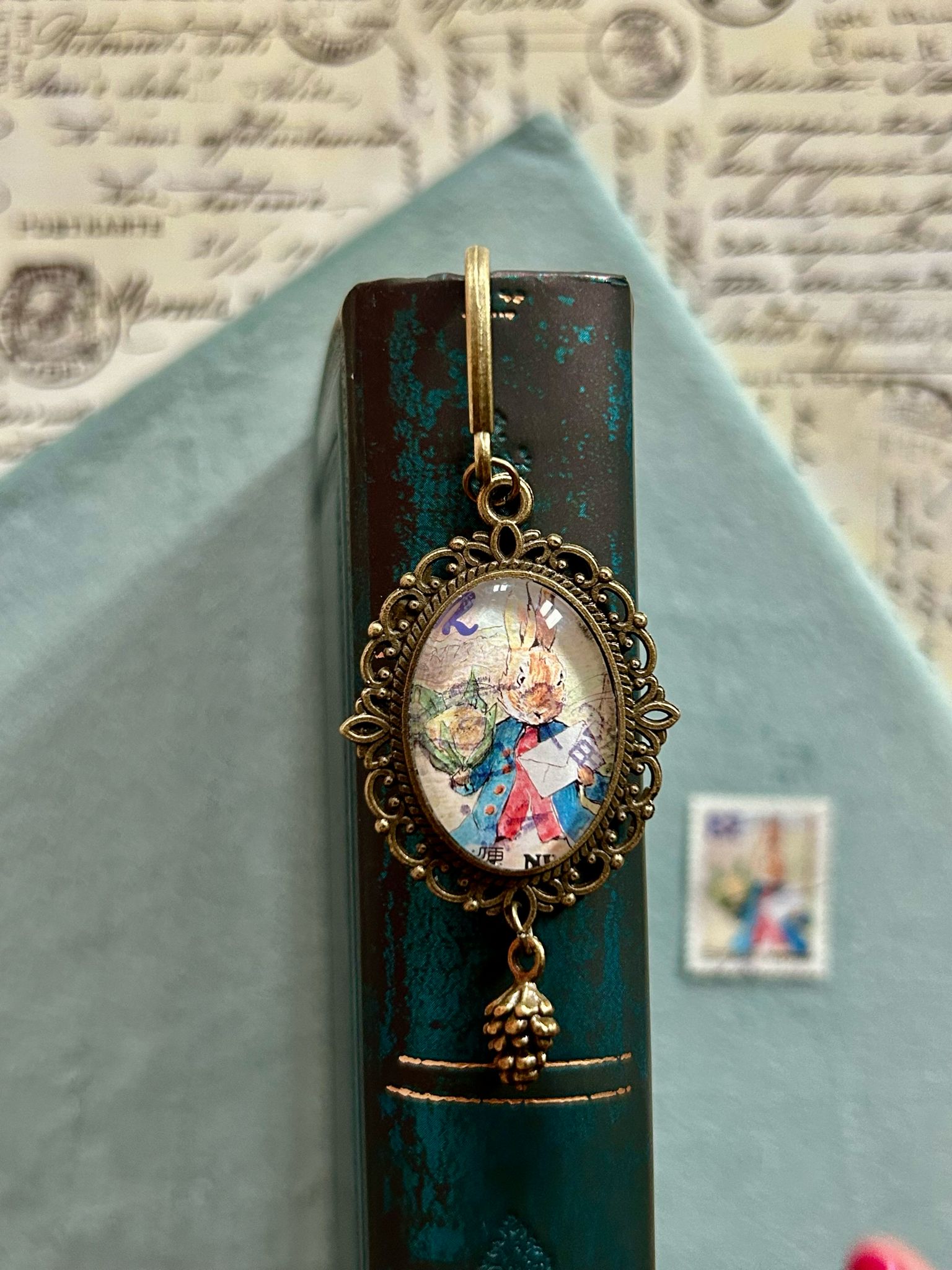 Segnalibro con ciondolo ovale in bronzo e francobollo giapponese di Peter Rabbit elegante all'appuntamento, di Beatrix Potter