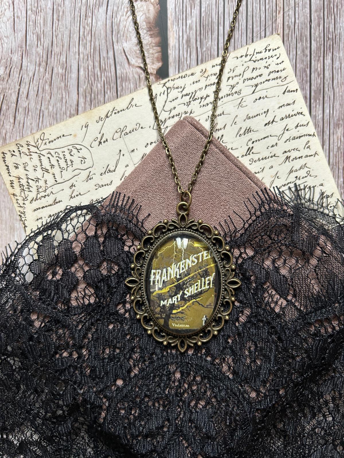 Ciondolo ovale in bronzo con la copertina di Frankenstein di Mary Shelley, paesaggio cupo e fulmine