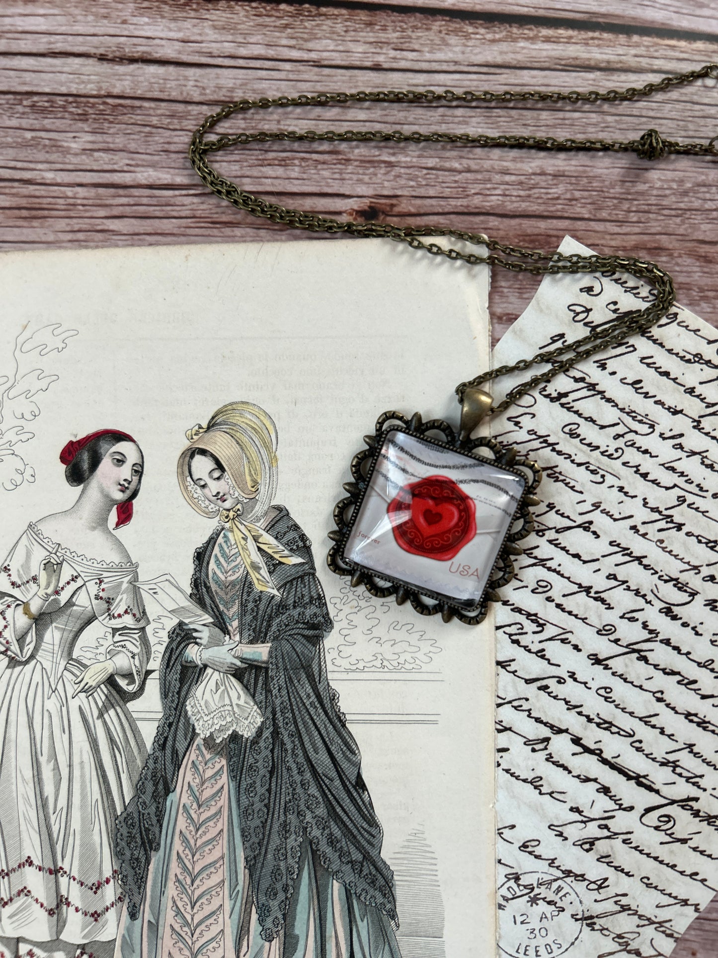 Collana creata con un francobollo americano che rappresenta una lettera d'amore con sigillo a forma di cuore.