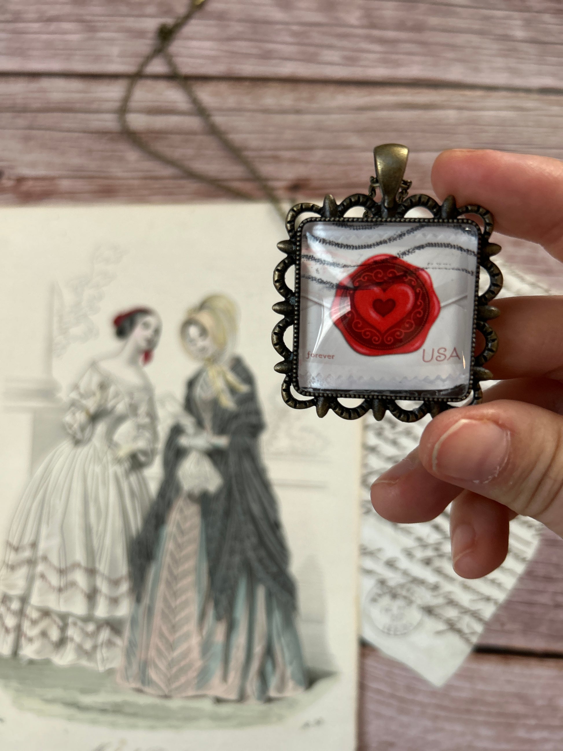 Collana creata con un francobollo americano che rappresenta una lettera d'amore con sigillo a forma di cuore.