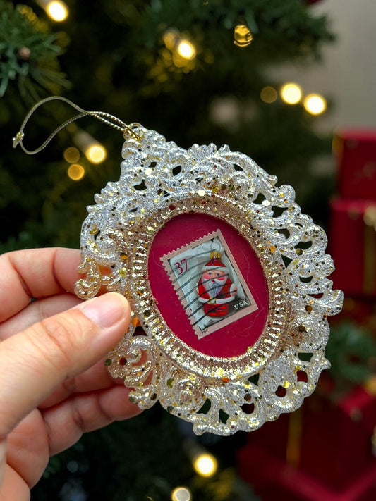 Addobbo natalizio rosso fatto a mano in Italia, tenuto in mano davanti a un albero di Natale con luci