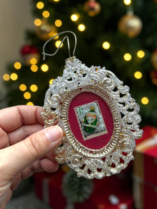Addobbo natalizio verde fatto a mano in Italia, tenuto in mano davanti all'albero di Natale illuminato
