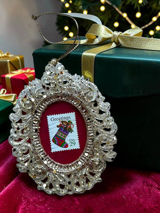 Addobbo natalizio artigianale italiano con calza di Natale su francobollo d'epoca, tenuto in mano davanti all'albero