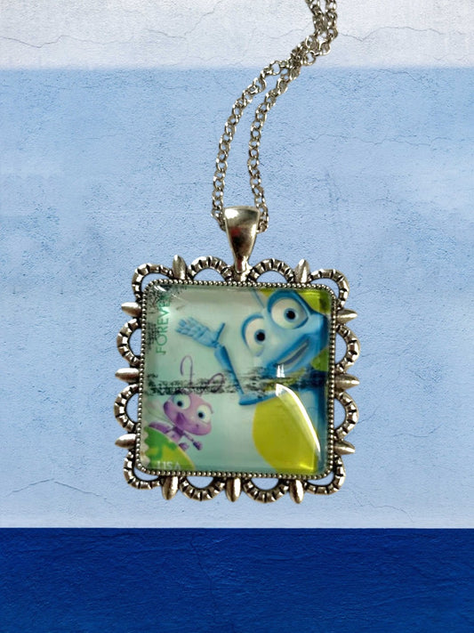 Dettaglio del francobollo di A Bug's Life con Flik e Dot in collana artigianale italiana, montatura argentata