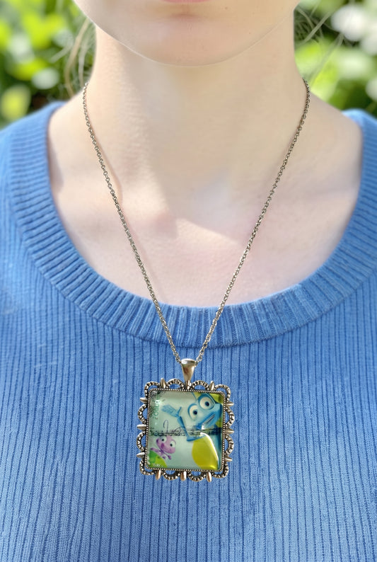 Collana artigianale indossata con francobollo americano di A Bug's Life, Flik e Dot, montatura argentata, fatta in Italia
