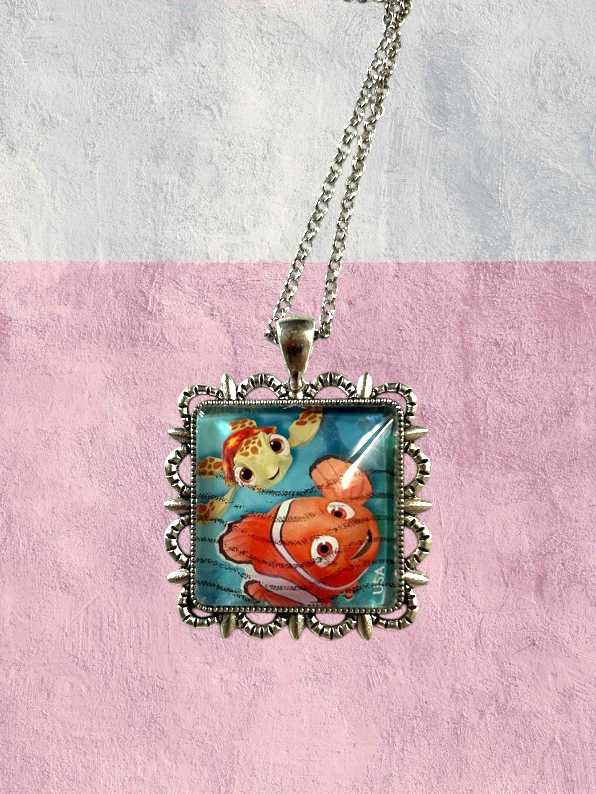 Dettaglio del francobollo di Alla ricerca di Nemo con Nemo e Guizzo, collana artigianale italiana, montatura argentata