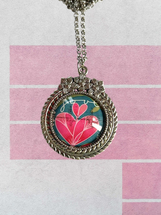 Collana artigianale italiana con francobollo di un cuore rosa e foglie, serie dell'amore, cornice argentata a fiori