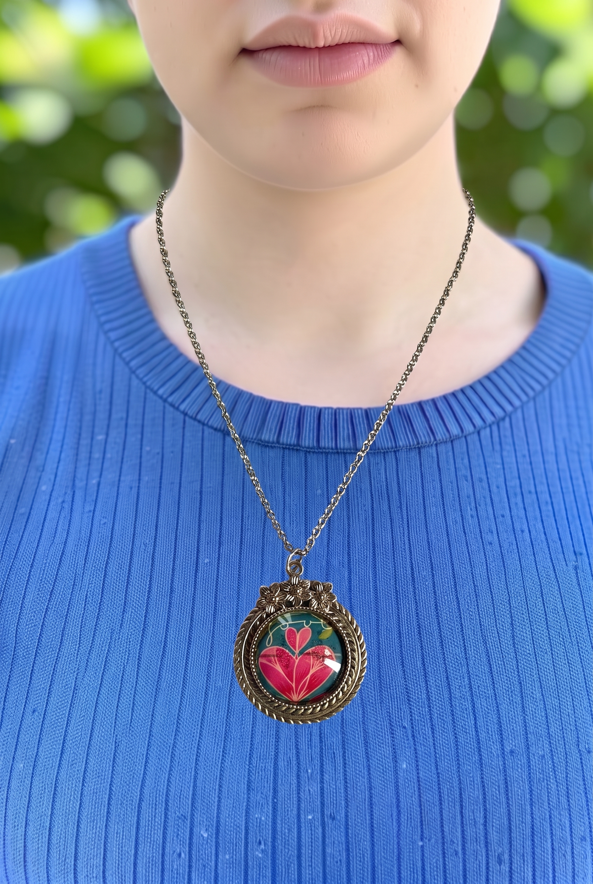Collana artigianale indossata con francobollo americano di un cuore rosa fiorito, cornice argentata a fiori, Italia