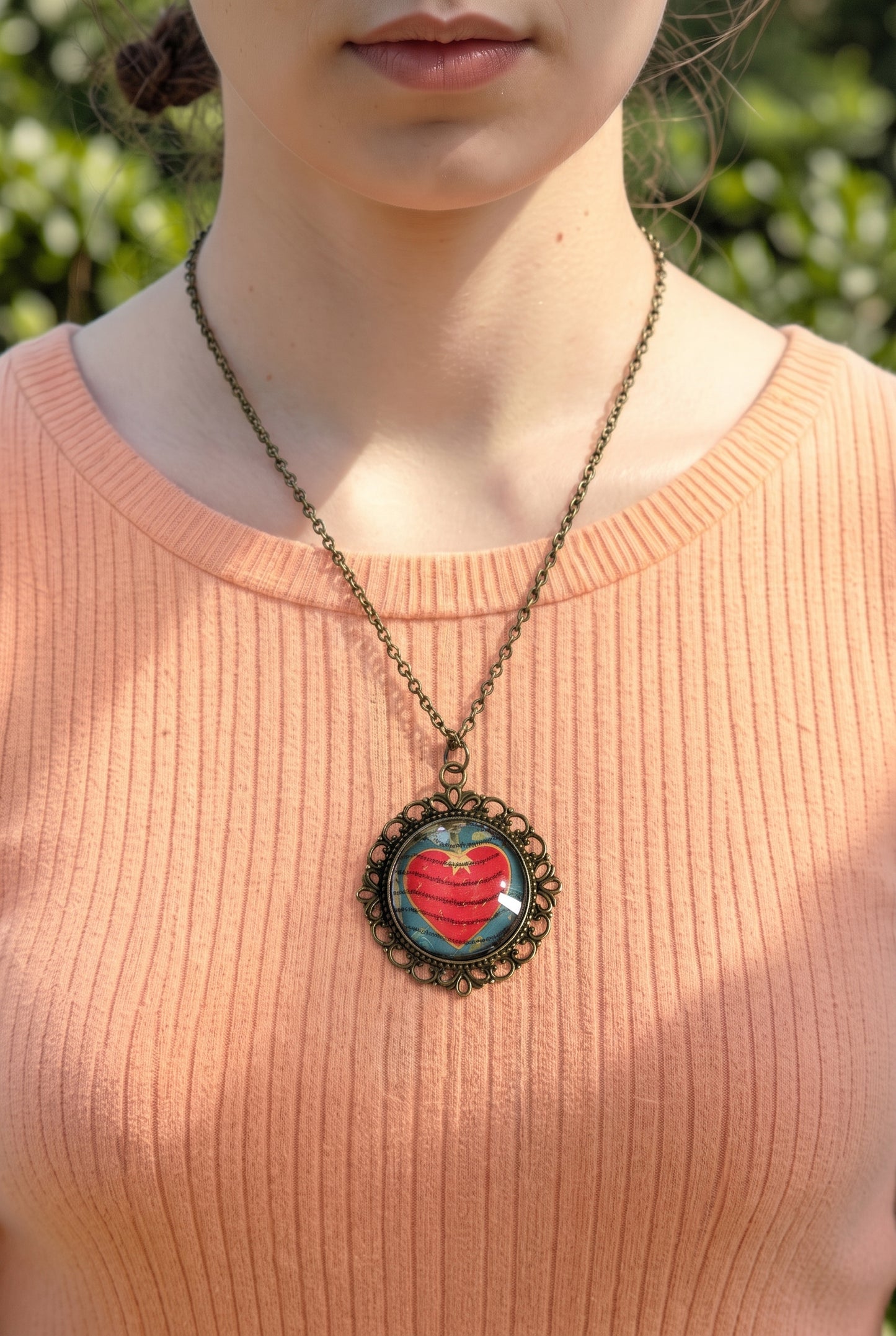 Collana artigianale indossata con francobollo americano di un cuore rosso e scritta love, cornice bronzo, Italia