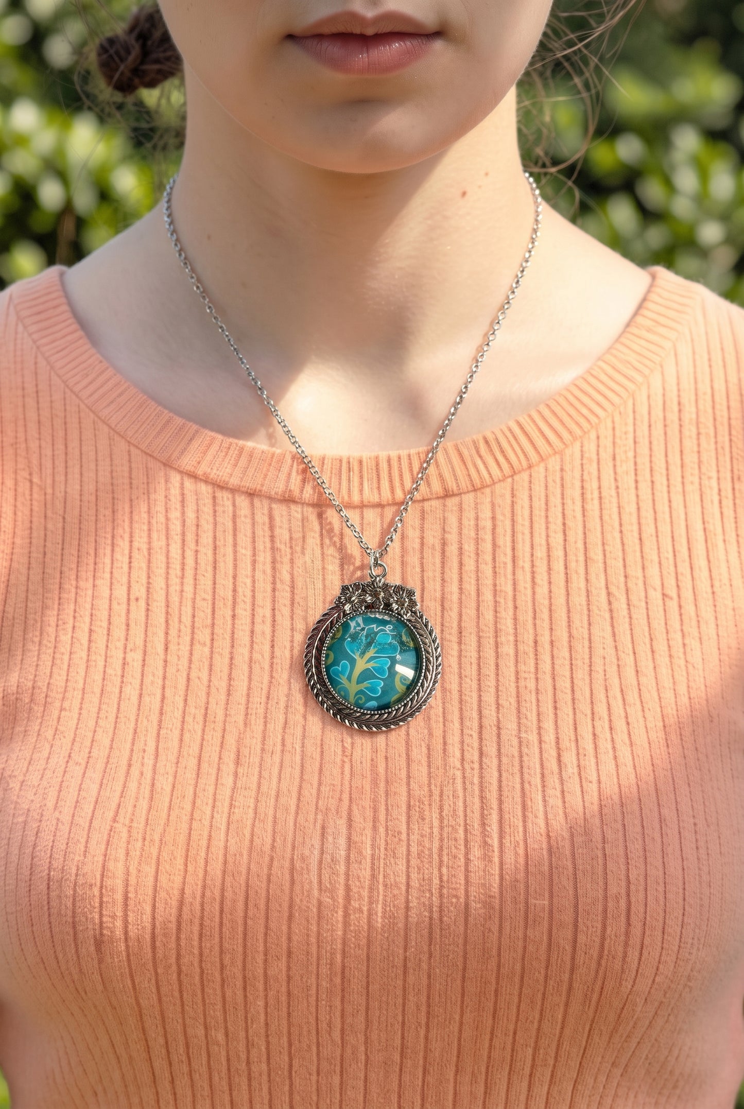 Collana artigianale indossata con francobollo americano di un fiore turchese, cornice argentata a fiori, Italia