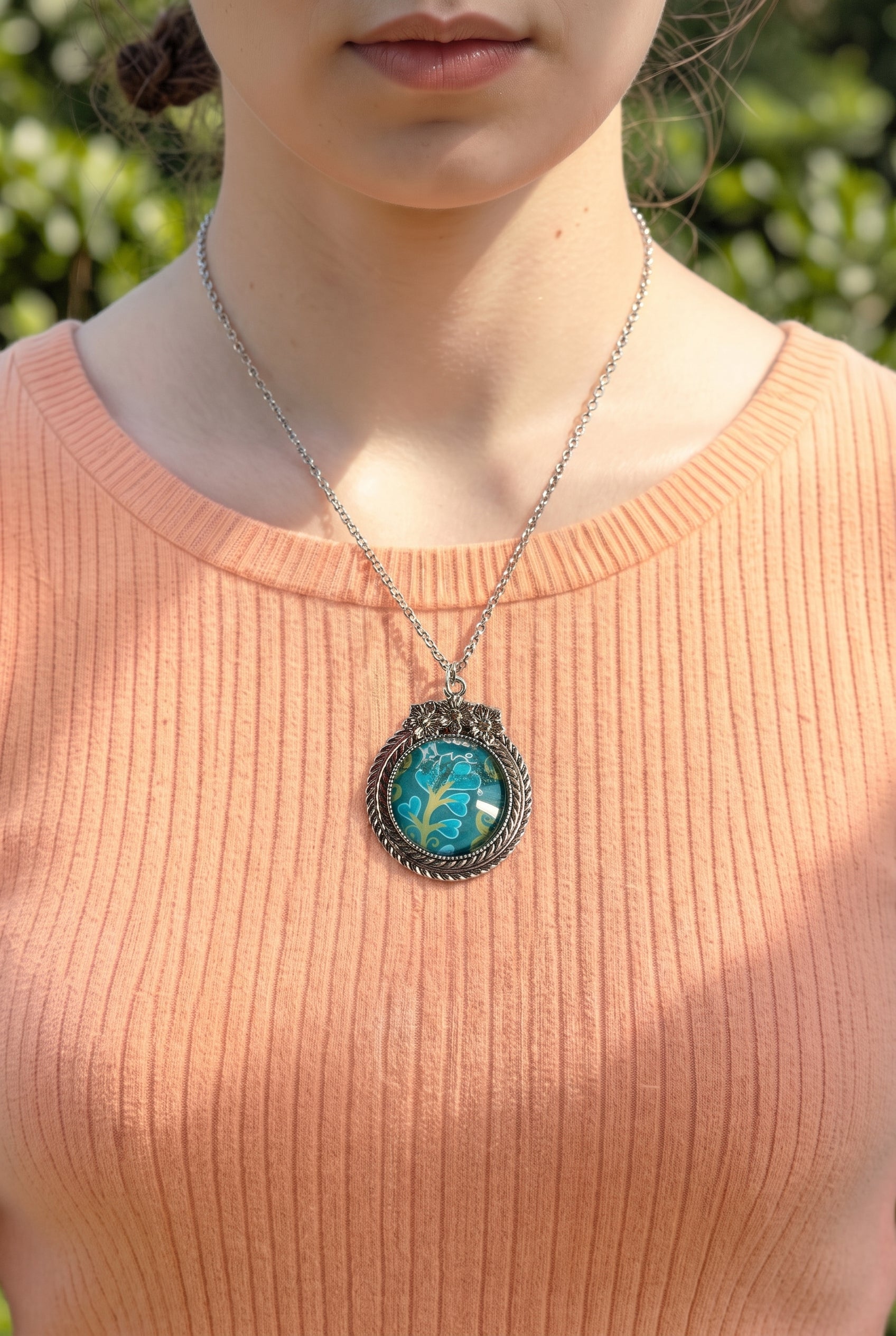 Collana artigianale indossata con francobollo americano di un fiore turchese, cornice argentata a fiori, Italia