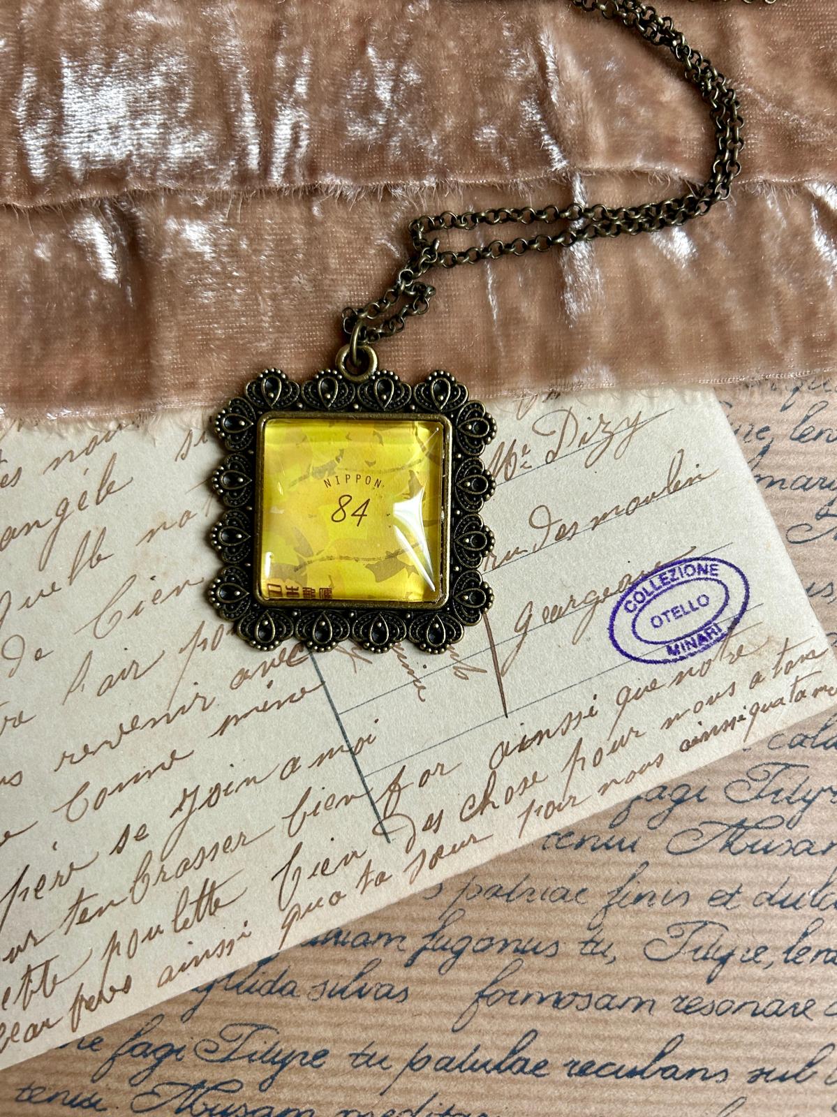 Collana con ciondolo quadrato e francobollo giapponese: foglia di ginkgo dorata d'autunno su fondo chiaro