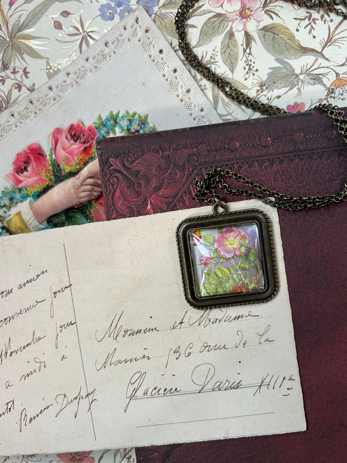 Collana quadrata con francobollo dell'Isola di Man: una rosa selvaggia (dog rose), su lettere antiche