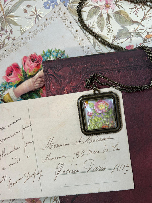 Collana quadrata con francobollo dell'Isola di Man: una rosa selvaggia (dog rose), su lettere antiche