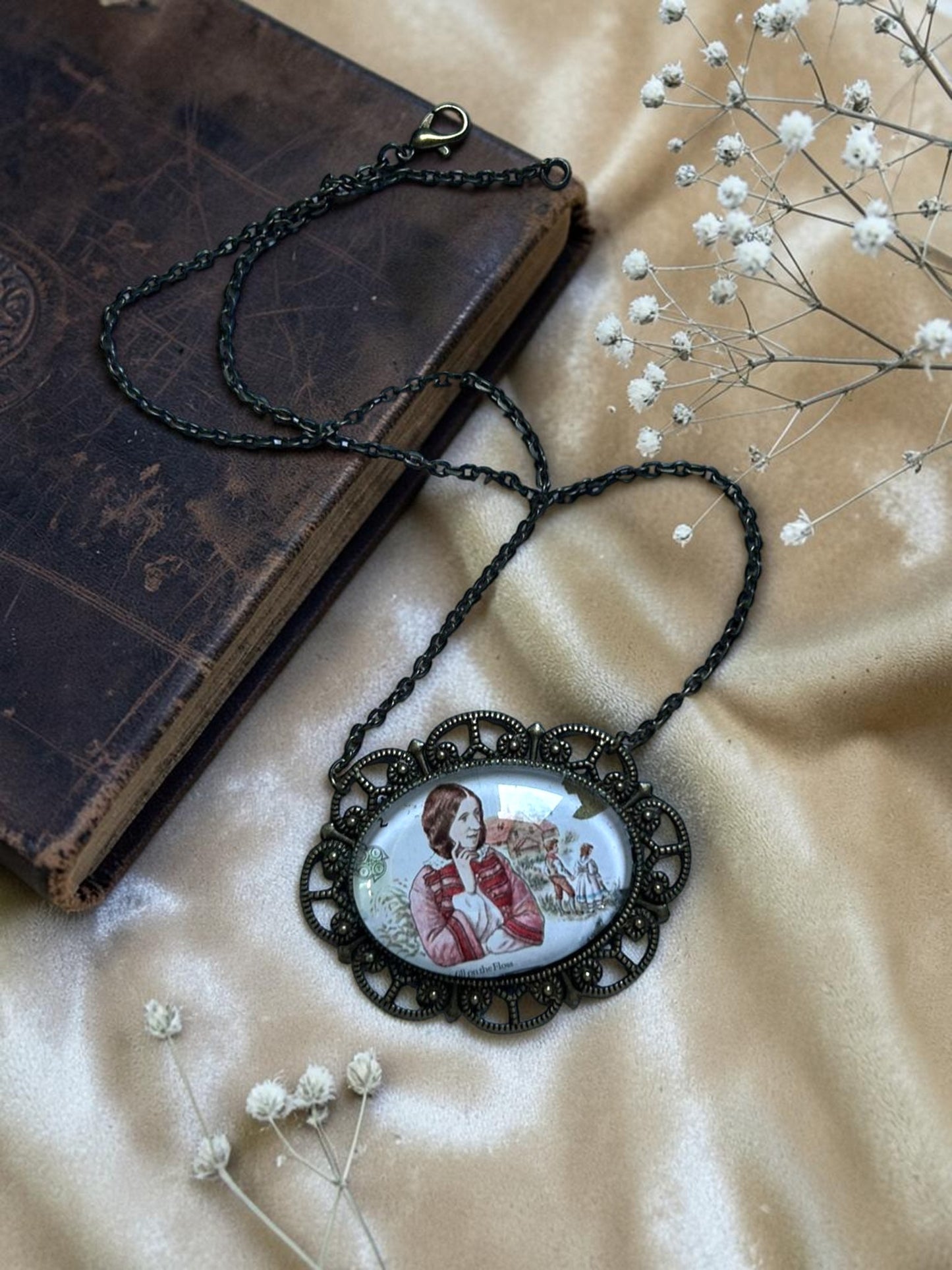 Collana ovale distesa su sfondo neutro, francobollo inglese del 1980 di George Eliot, Il mulino sulla Floss