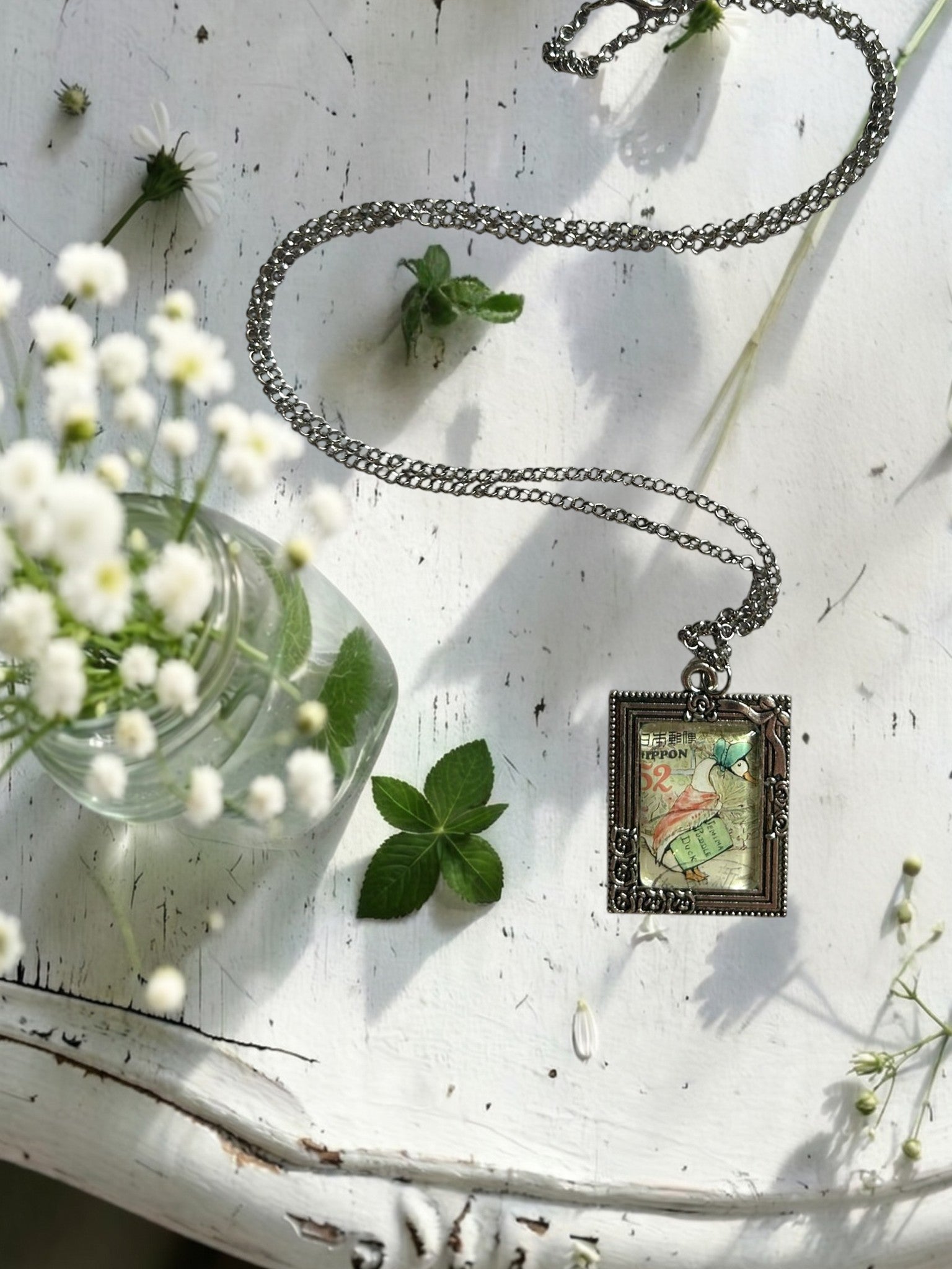 Collana con francobollo giapponese di Jemima, l'anatra di Beatrix Potter con cuffietta e scialle, cornice rettangolare in argento con rose, artigianato, Italia