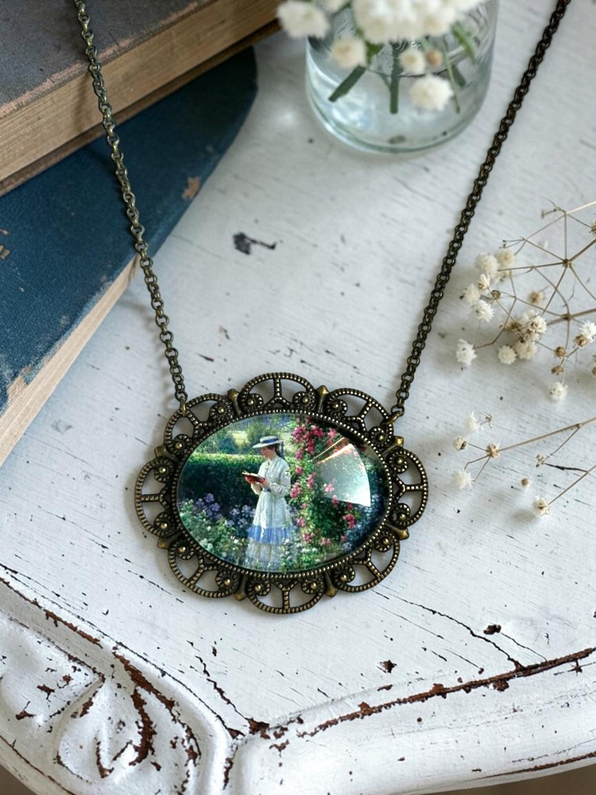 Collana artigianale italiana con lettrice nel giardino di Blair Leighton, su tavolino bianco con libri antichi