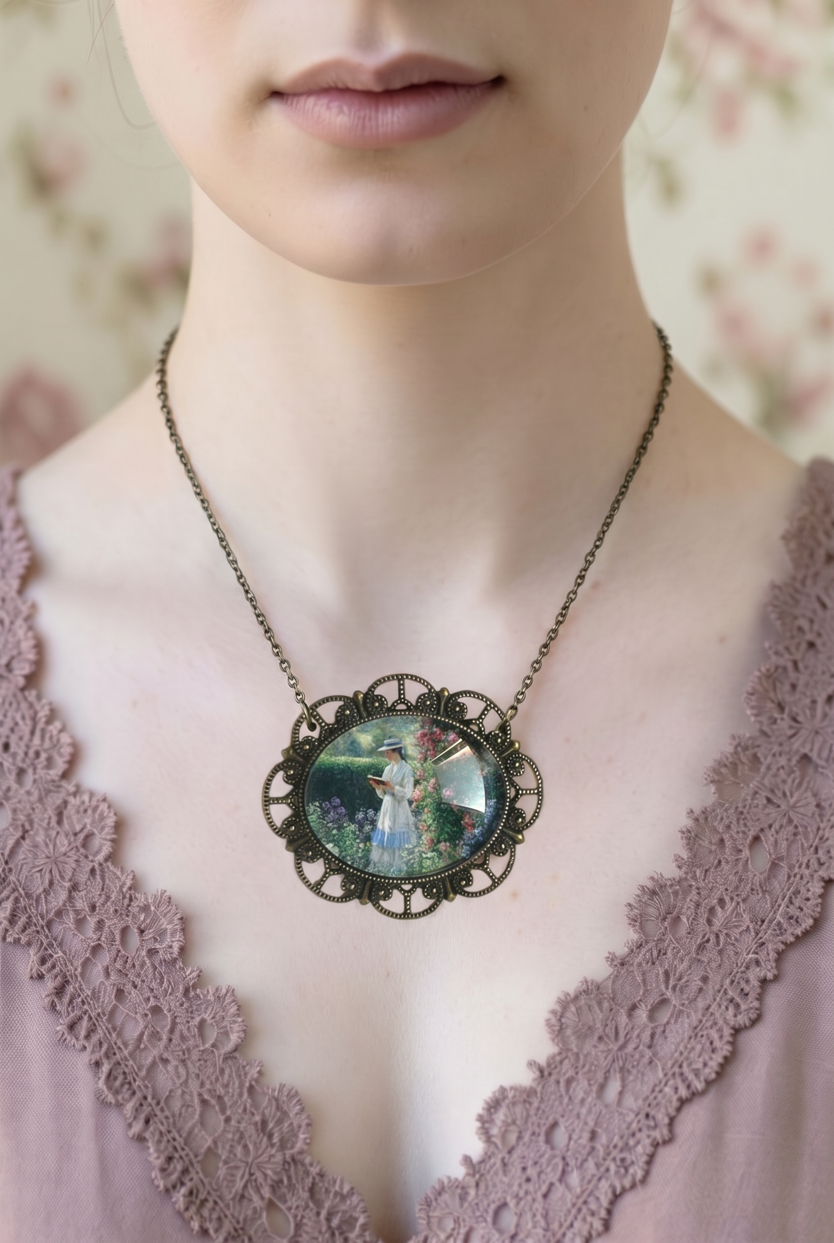 Collana artigianale italiana, ciondolo ovale con lettrice nel giardino, indossata con abito in pizzo rosa