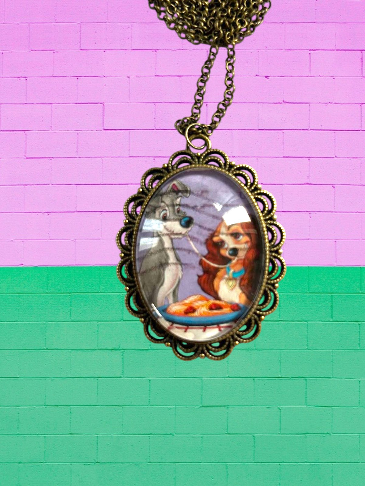 Collana artigianale con francobollo di Lilli e il Vagabondo su muro rosa e verde, cornice bronzo, Italia