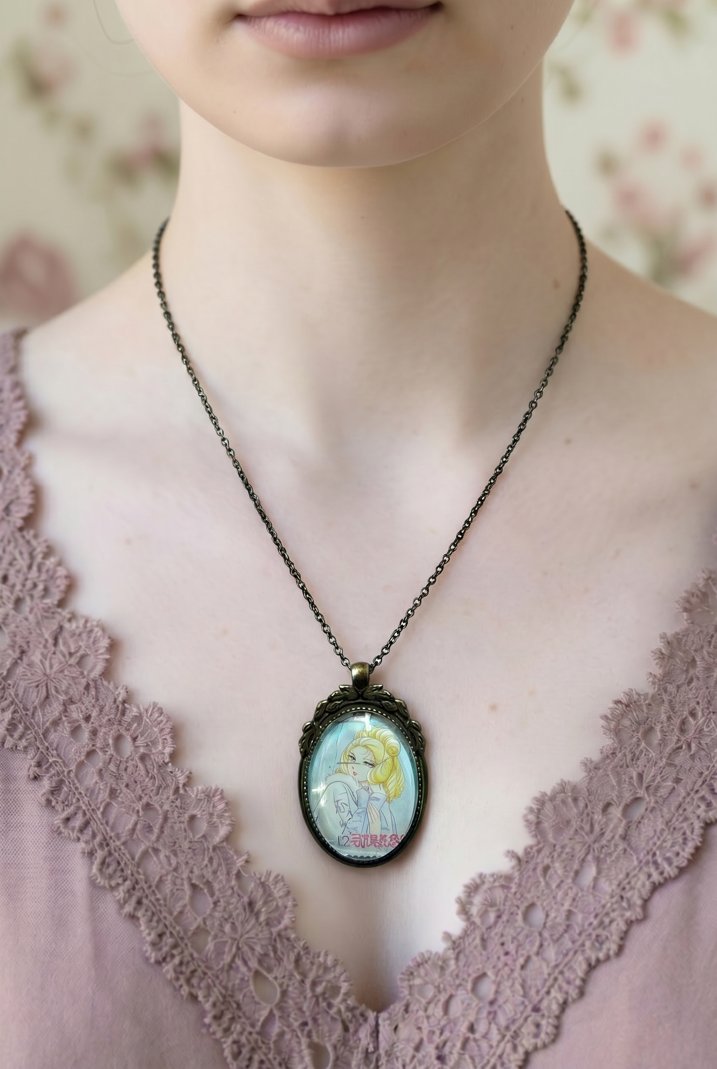 Collana con ciondolo ovale in bronzo e francobollo giapponese di Maria Antonietta indossata su abito di pizzo, da Lady Oscar