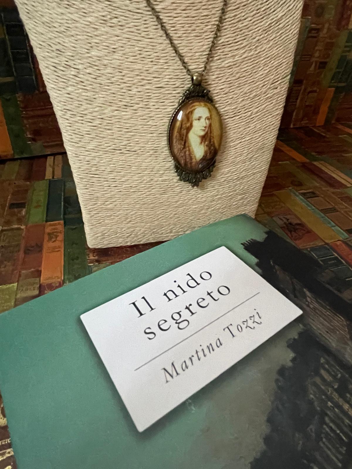 Collana in bronzo con ciondolo ovale e ritratto di Mary Shelley, cornice a rose, su espositore