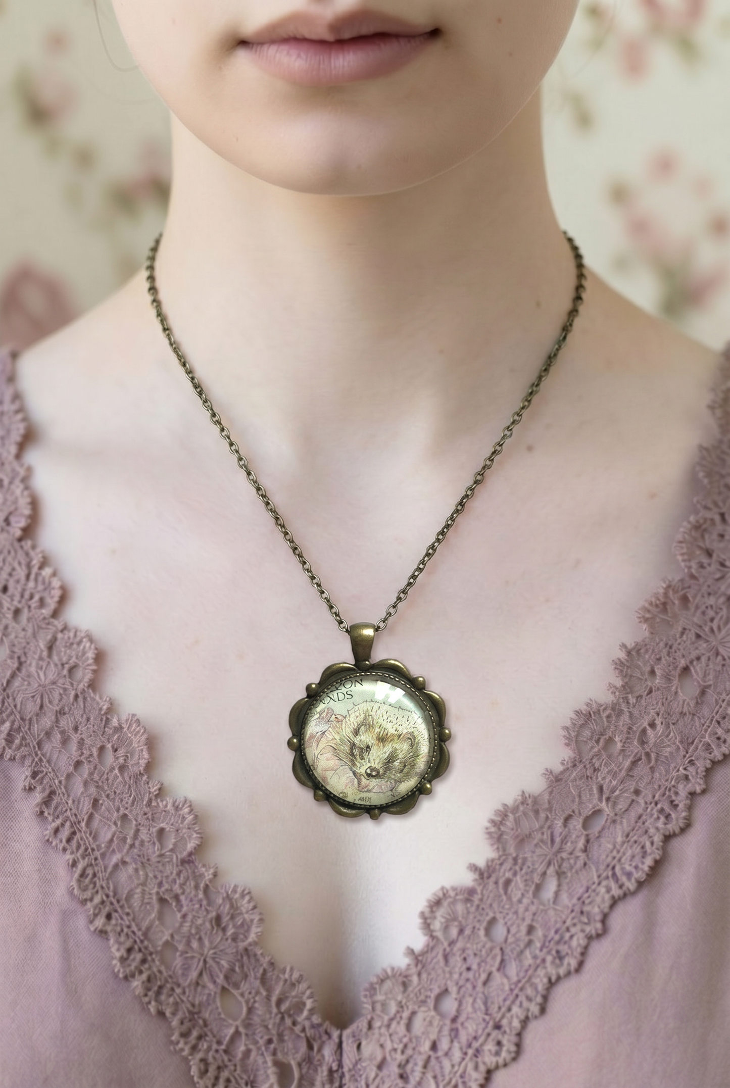 Collana con francobollo di Mrs Tiggy-Winkle, il riccio di Beatrix Potter, cornice tonda in bronzo con petali in rilievo, indossata