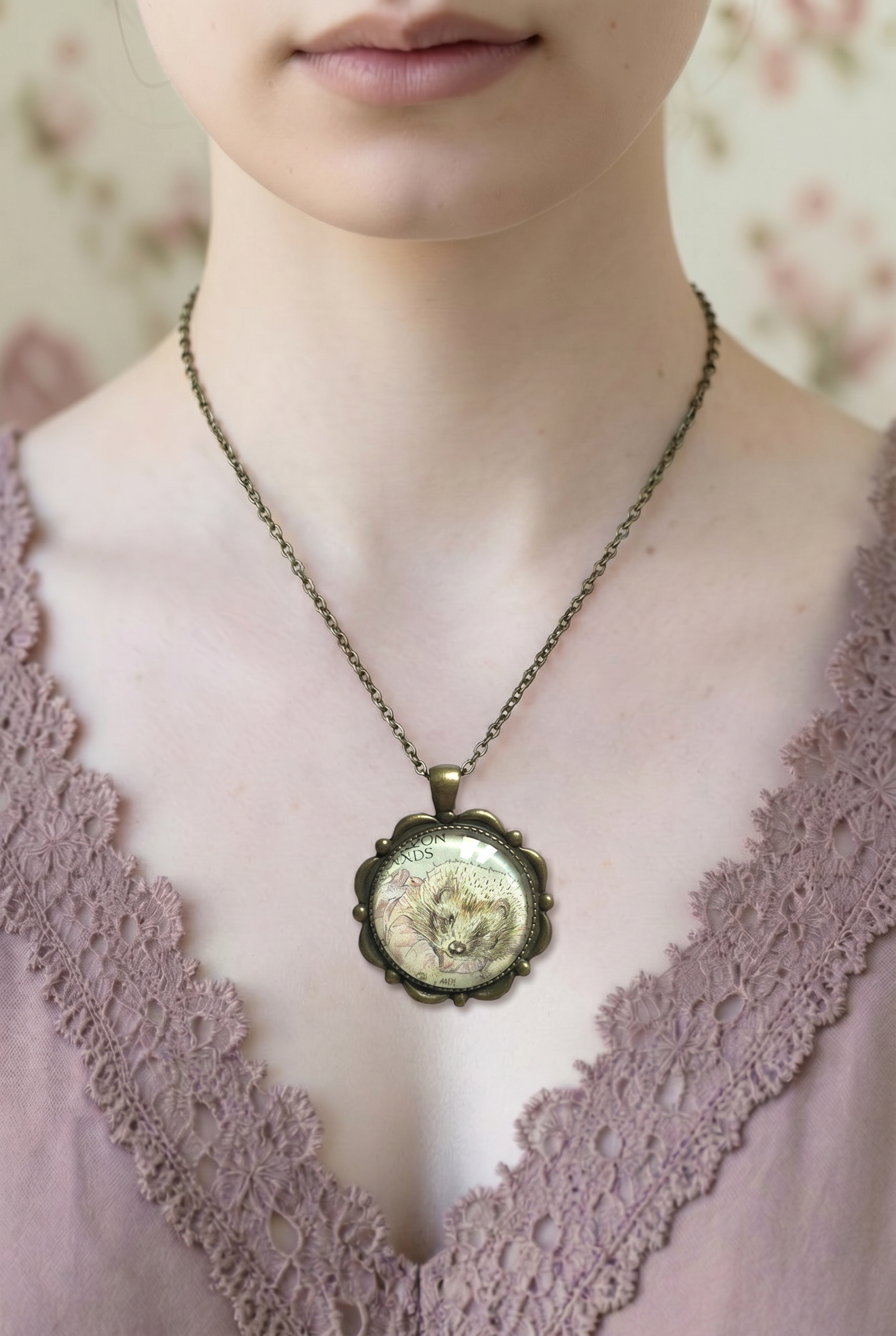 Collana con francobollo di Mrs Tiggy-Winkle, il riccio di Beatrix Potter, cornice tonda in bronzo con petali in rilievo, indossata