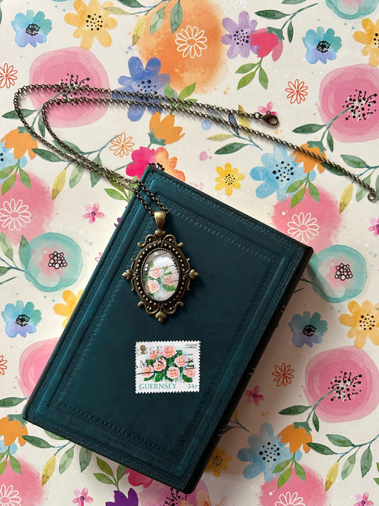 Collana ovale con bordi lavorati e francobollo d'epoca Guernsey con rose rosa