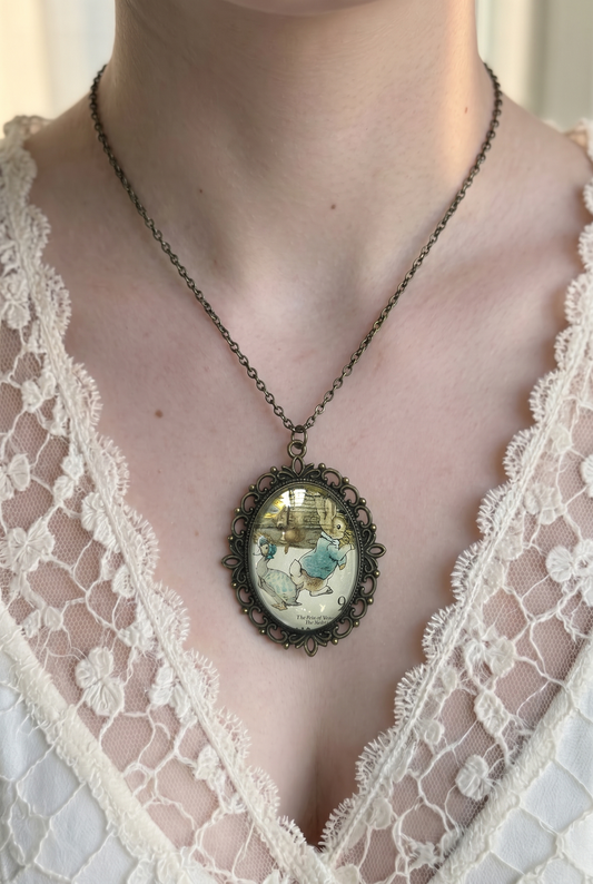 Collana con francobollo d'epoca inglese del 1979 di Peter Rabbit di Beatrix Potter, cornice ovale in bronzo a filigrana, indossata