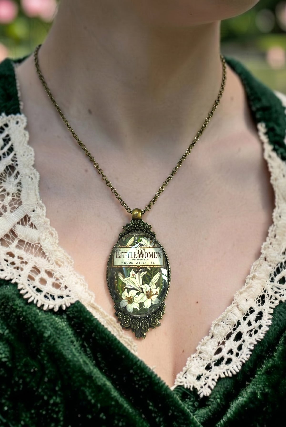 Collana indossata con ciondolo ovale e copertina vintage di Piccole Donne (Little Women), cornice color bronzo con rose, artigianato, Italia