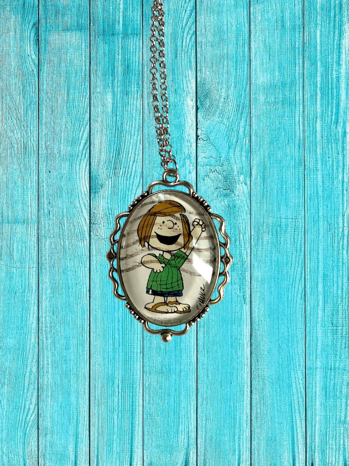 Collana artigianale con francobollo americano di Piperita Patty dei Peanuts su legno turchese, creata in Italia
