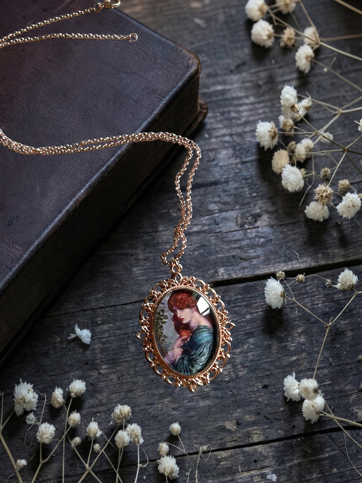 Ciondolo ovale in bronzo con Proserpina di Rossetti, collana preraffaellita fotografata in piano tra dettagli botanici, artigianato, Italia