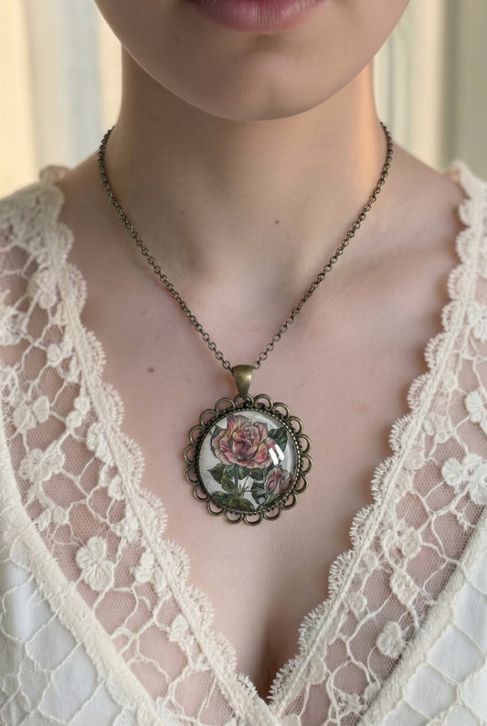 Collana indossata con ciondolo tondo e francobollo della rosa Silver Jubilee, cornice lavorata dai toni caldi