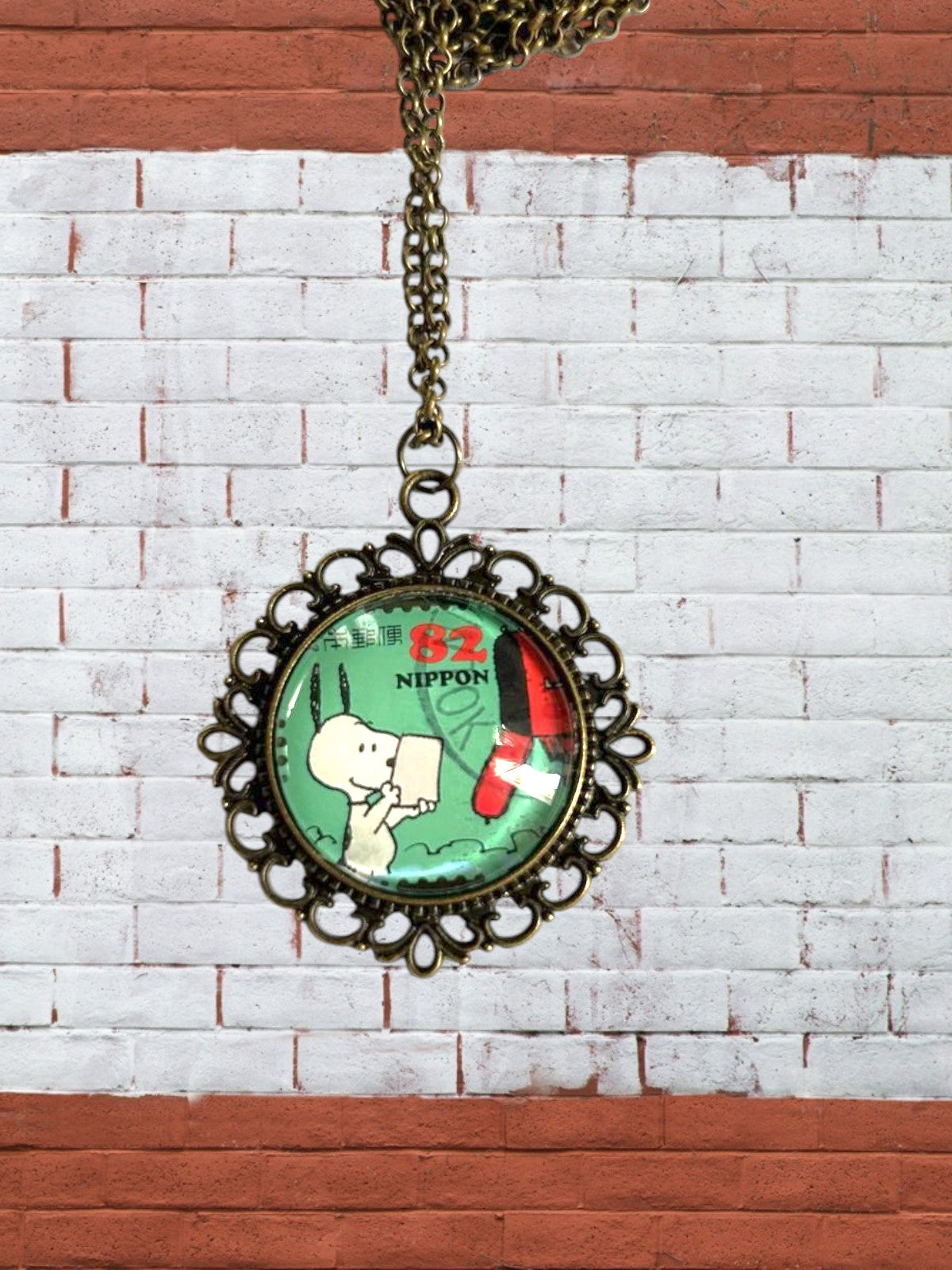 Collana artigianale con francobollo giapponese di Snoopy che scrive, cornice bronzo, made in Italy