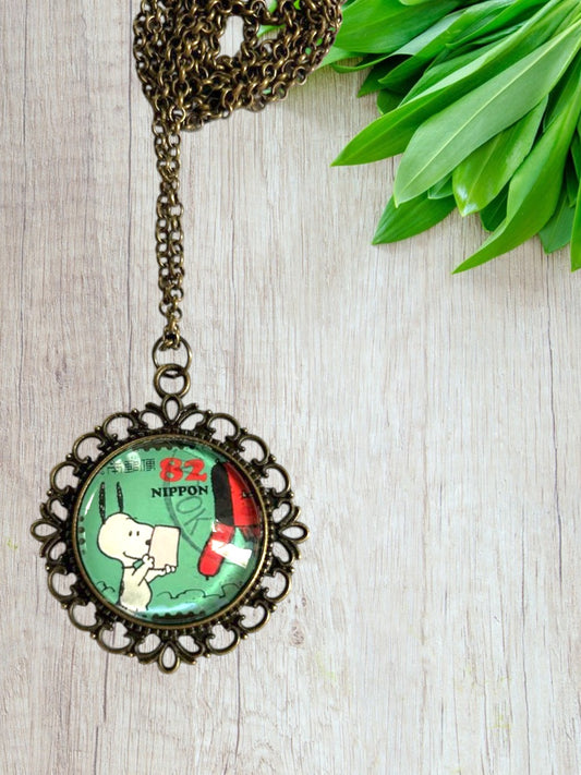 Collana artigianale con francobollo Snoopy dei Peanuts su fondo legno naurale, idea regalo, cornice bronzo, Italia