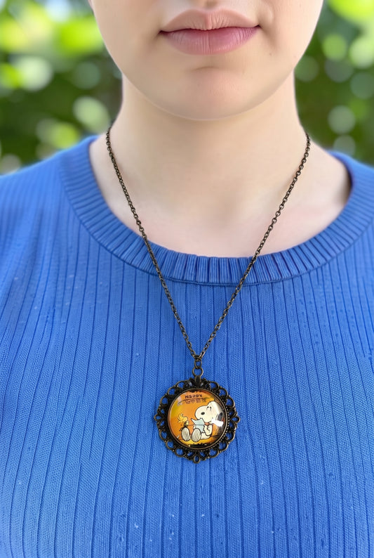 Collana artigianale indossata con francobollo giapponese di Snoopy e Woodstock che leggono, cornice bronzo, Italia