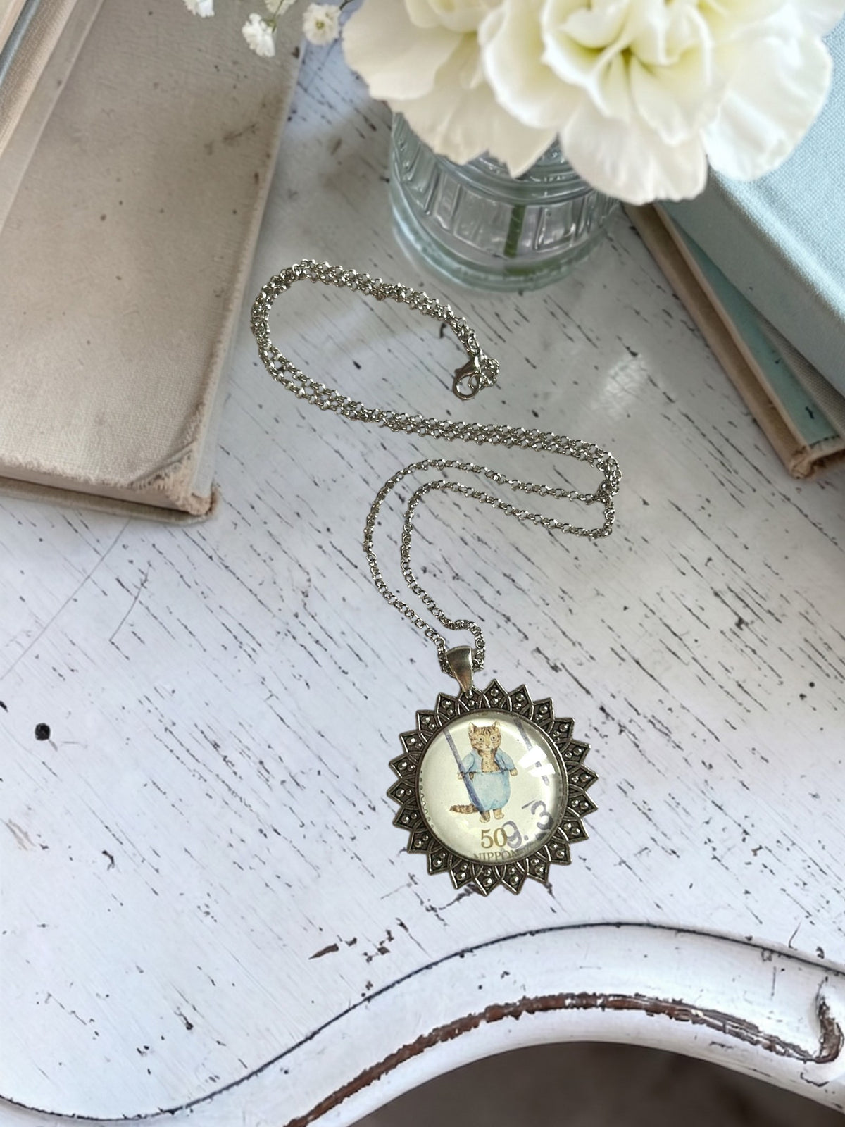 Collana con francobollo giapponese di Tom Kitten, il gattino di Beatrix Potter in completo azzurro, cornice tonda in argento a raggiera, artigianato, Italia