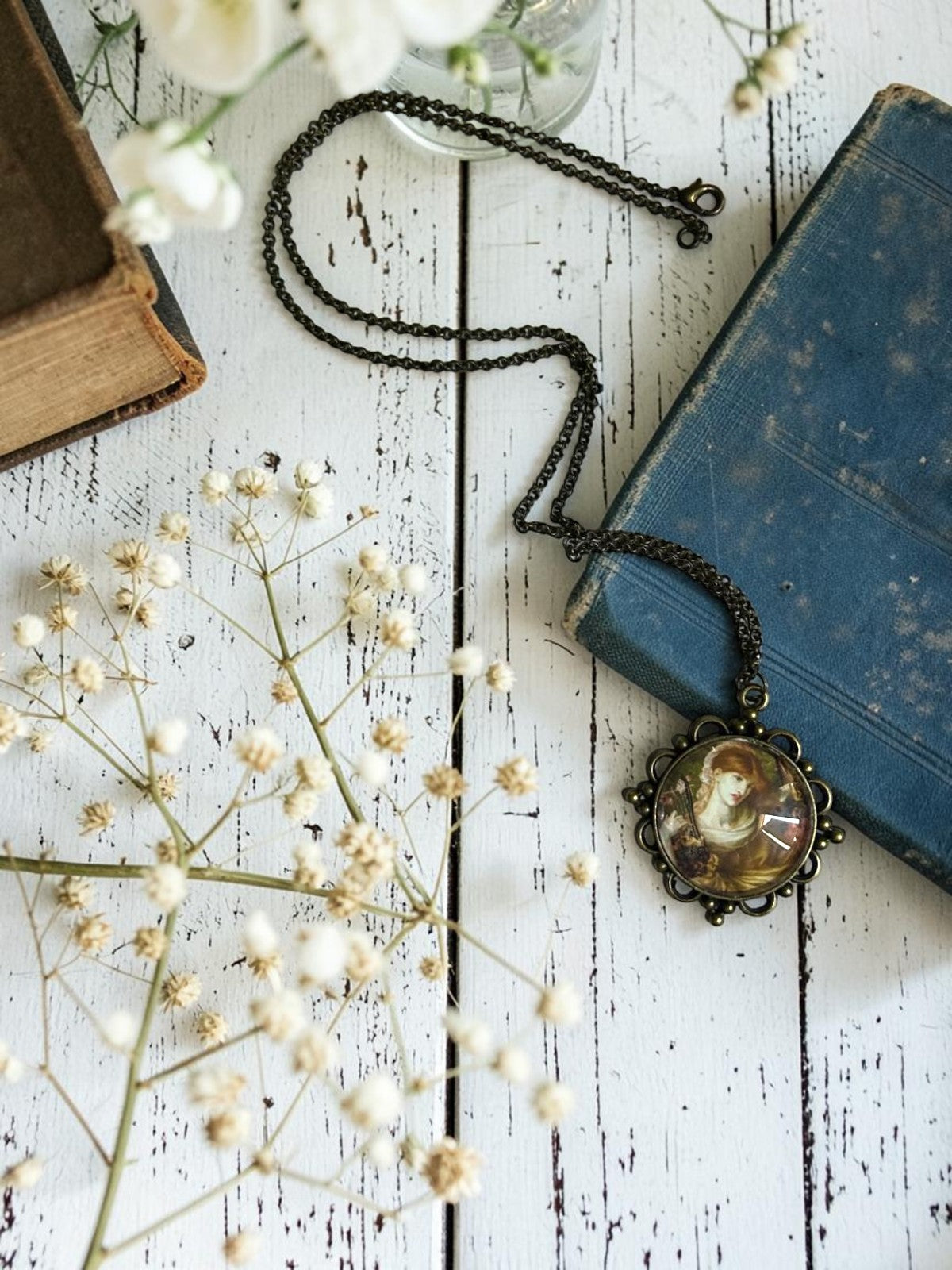 Ciondolo tondo in bronzo con La Vedova Romana di Rossetti, collana preraffaellita fotografata in piano tra rose e dettagli, artigianato, Italia