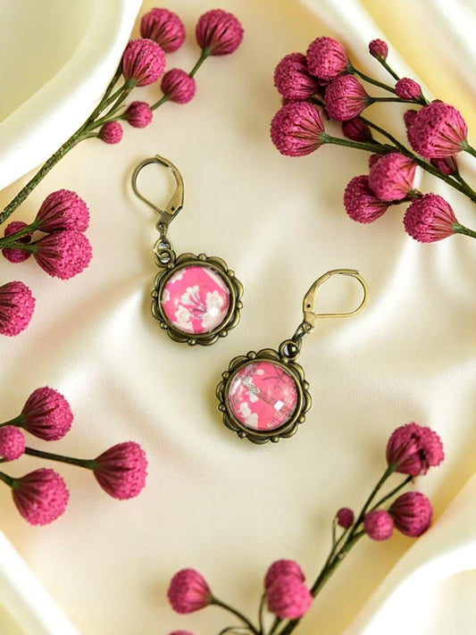 Orecchini con fiori rosa da francobollo giapponese del 1968 tenuti in mano, montatura tonda bronzo