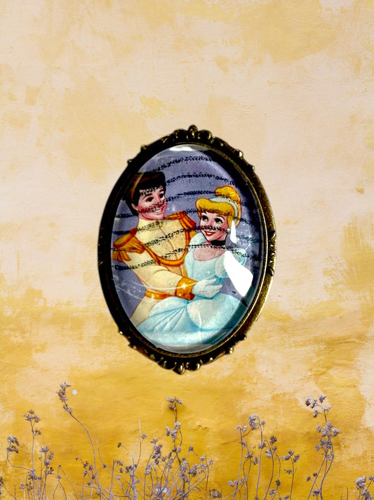 Spilla artigianale con francobollo americano di Cenerentola, cornice bronzo ovale, muro giallo con fiori