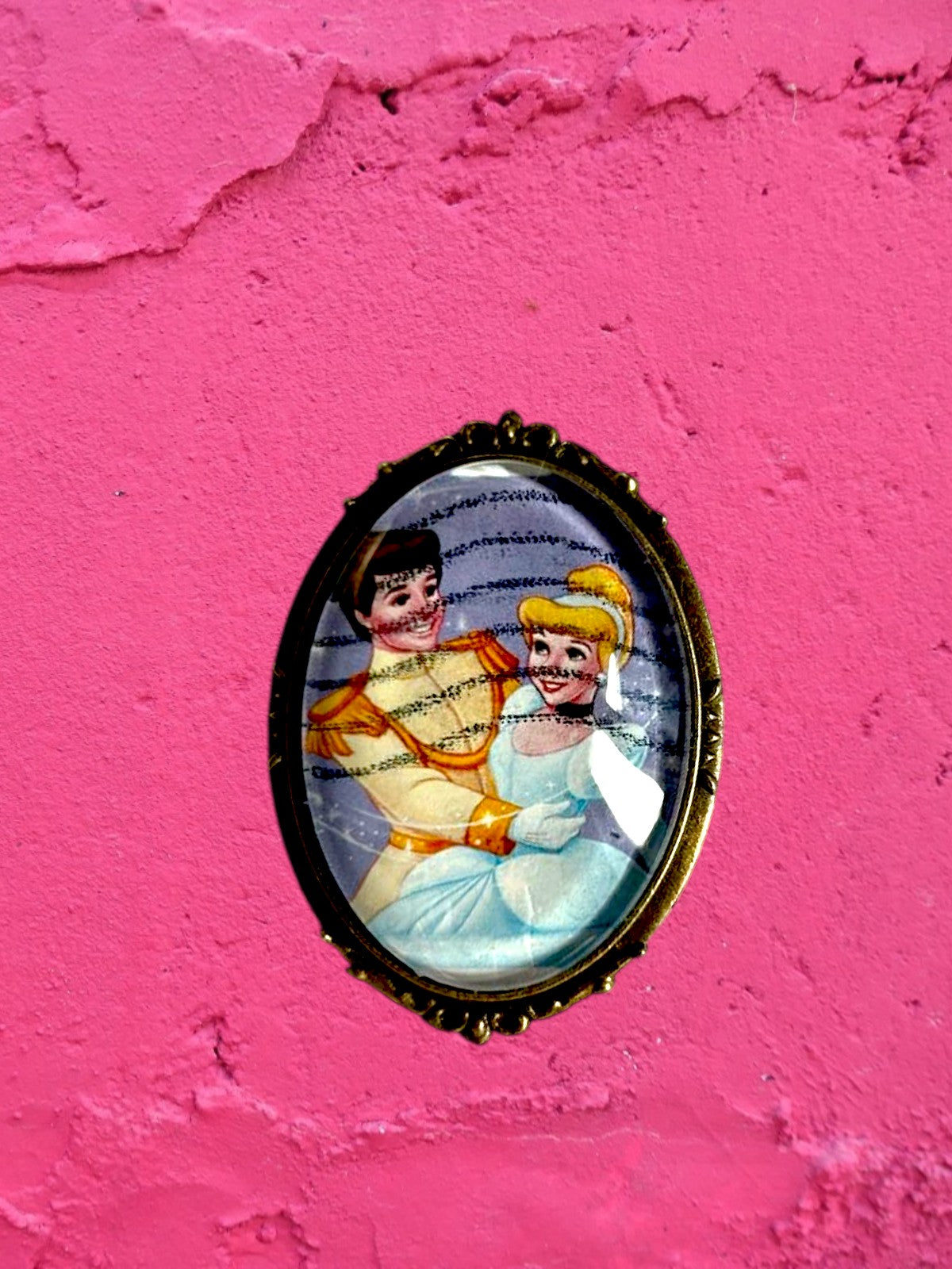 Spilla artigianale con francobollo americano di Cenerentola, cornice bronzo ovale, muro rosa